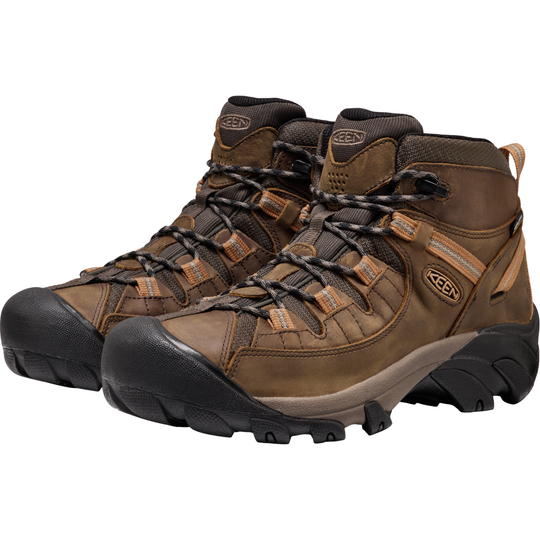 Pair of brown hiking boots with black soles on a white background