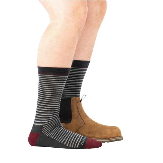 Striped socks worn with brown boots on a white background