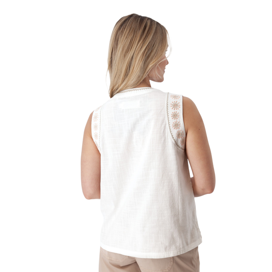 Woman wearing a white sleeveless top with lace details on a white background