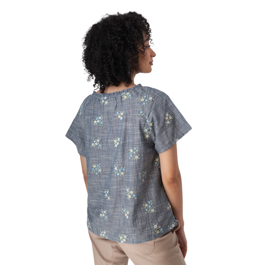 Woman wearing a blue floral short-sleeve shirt on a white background