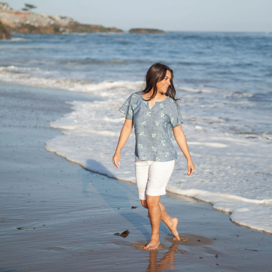 Woman walking on a beach with ocean waves in the background