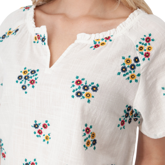White blouse with colorful floral embroidery on a white background