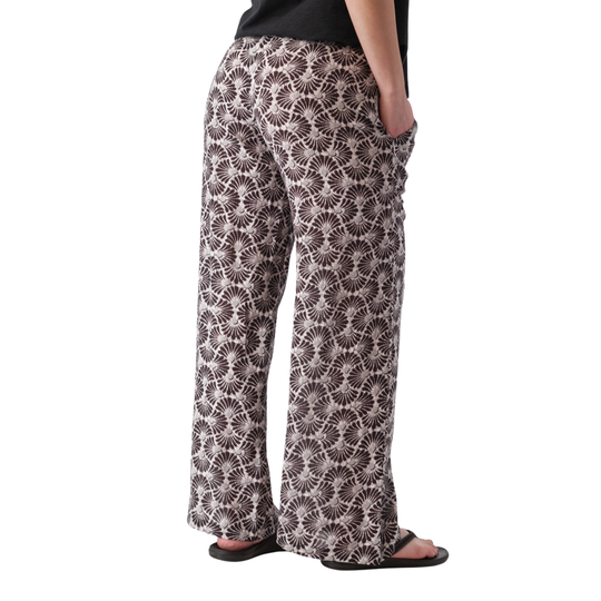Person wearing patterned pants on a white background