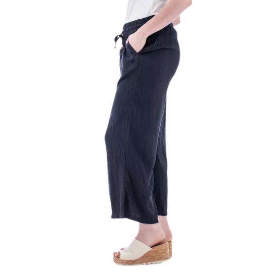 Person wearing navy blue wide-leg pants on a white background