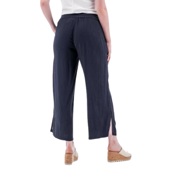 Person wearing navy wide-leg pants on a white background