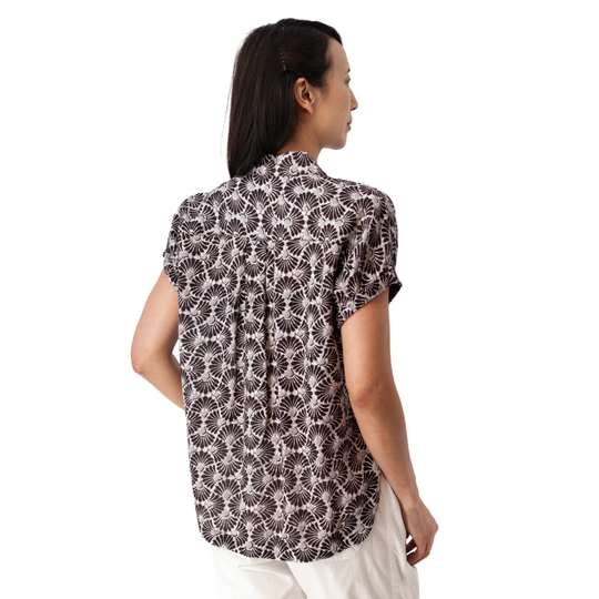 Woman wearing a sleeveless patterned top on a white background