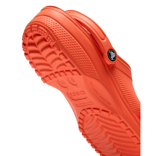 Close-up of an orange shoe sole with a brand logo on a white background