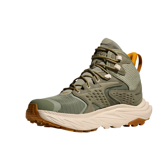 Green hiking boot with brown sole on a white background