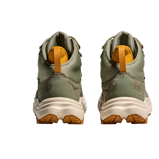 Pair of green hiking boots with orange accents on a white background