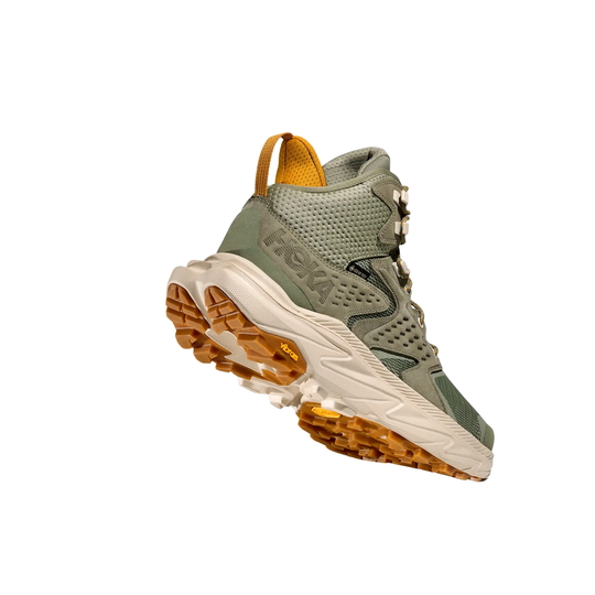 Green hiking boot with brown sole on a white background