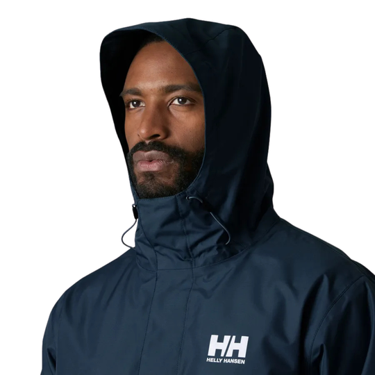 Person wearing a navy blue Helly Hansen jacket on a light gray background