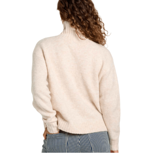 Person wearing a beige sweater with a white background