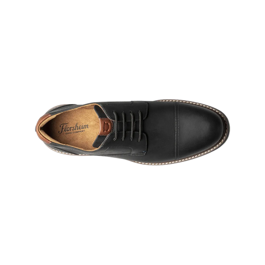 Black leather shoe with brown insole on a white background