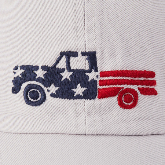 Cap with an embroidered design of a truck and American flag on a light gray background