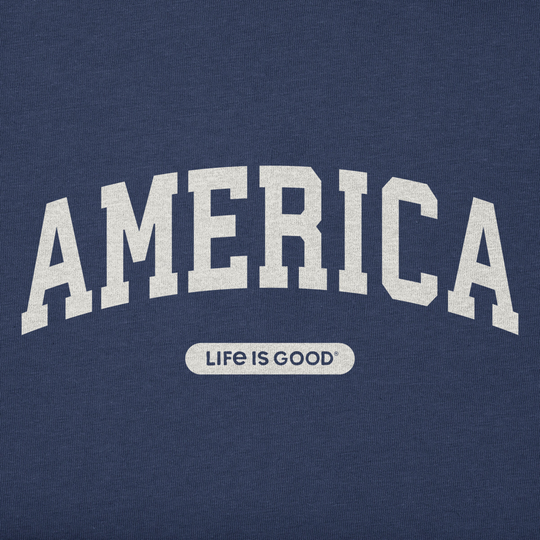 Navy blue shirt with 'AMERICA' printed in white and 'LIFE IS GOOD' logo below on a solid background.
