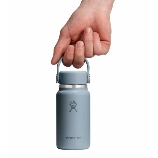 Hand holding a Gray Hydro Flask water bottle on a white background