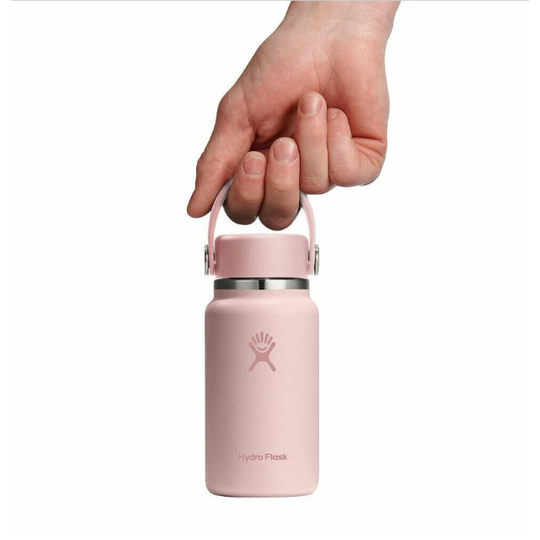 Pink Hydro Flask water bottle held by a hand on a white background