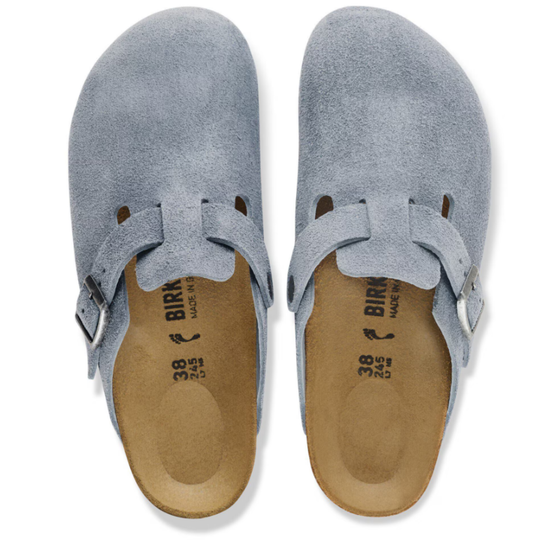 Pair of blue suede clogs with brown soles on a white background