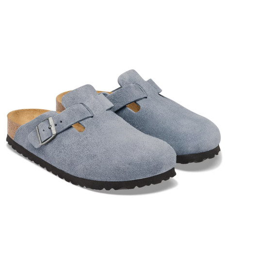 Pair of blue suede clogs with cork insole on a white background