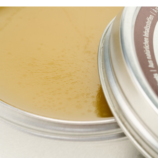 Close-up of a metal tin on a light background with conditioner in it
