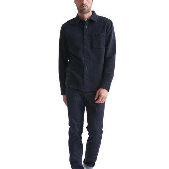 Man wearing a dark blue button-up shirt and jeans on a white background
