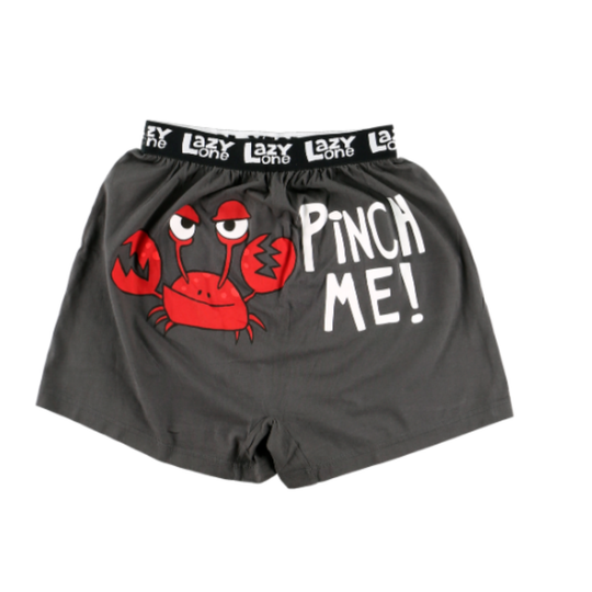 Gray boxer shorts with a red crab graphic and 'Pinch Me!' text on a white background
