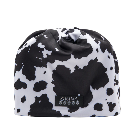Black and white cow print drawstring bag with 'Skida' logo on a white background