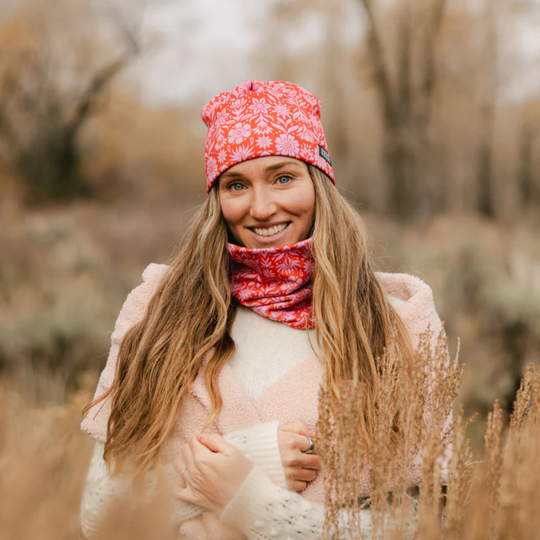 Woman wearing a red patterned headband and scarf in a natural setting