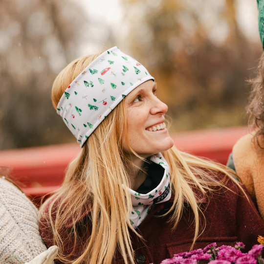 Woman wearing White and green trees wiht skiers on headband with matching neck warmer 