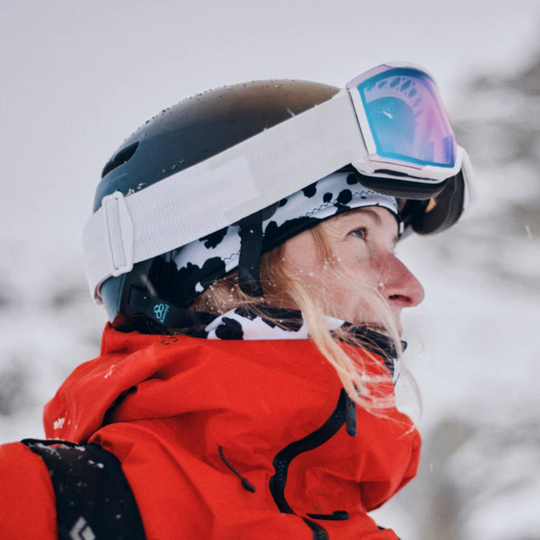 Woman wearing cow print headband with with matching neck warmer. Winter  snow background. 