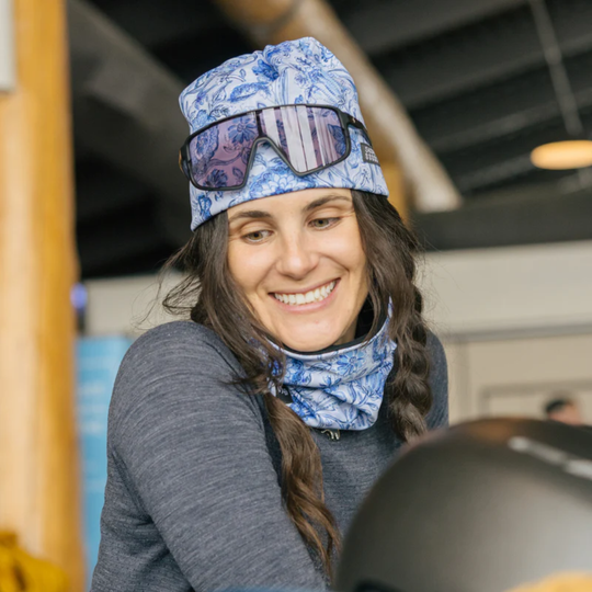 woman wearing Skida Alpine Fleece Neckwarmer - Amrita blue flower design on a blurred background