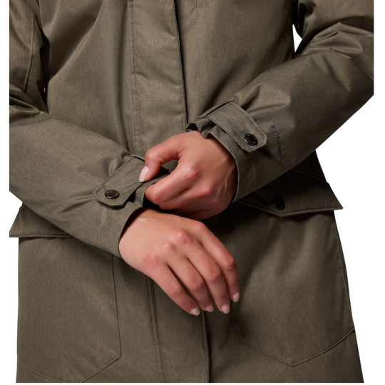 close up of woman wearing Columbia Women's Suttle Mountain Long Insulated Jacket - Stone Green on white background adjusting wrist sleeves