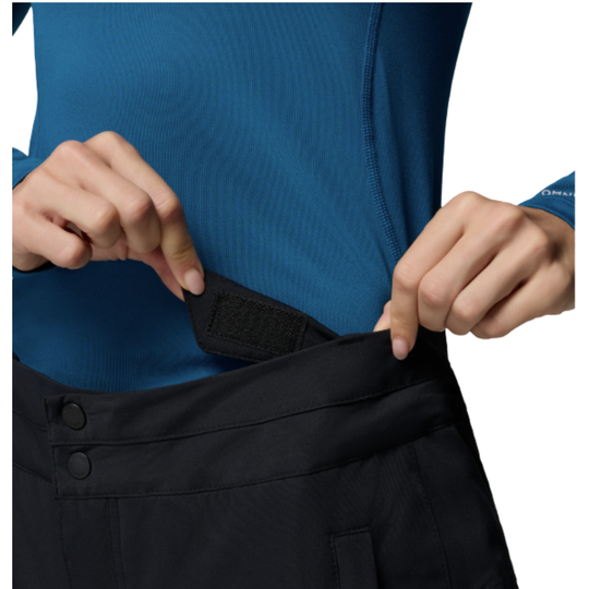 Woman wearing Columbia Women's Bugaboo III Snow Pants - Black on white background. zoomed in showing adjustable velcro waist