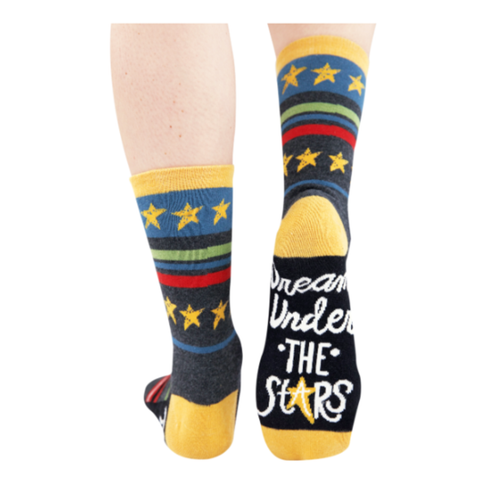 A pair of crew socks shown on lower legs against a plain white background. The socks have a dark navy base with yellow stars, yellow cuffs and toes, and horizontal stripes in blue, green, and red.