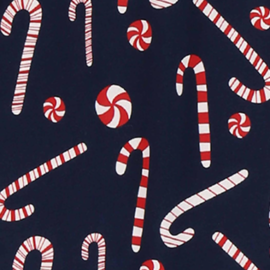 A close-up of a navy blue patterned surface featuring red and white striped candy canes and red-and-white swirl peppermint candies.