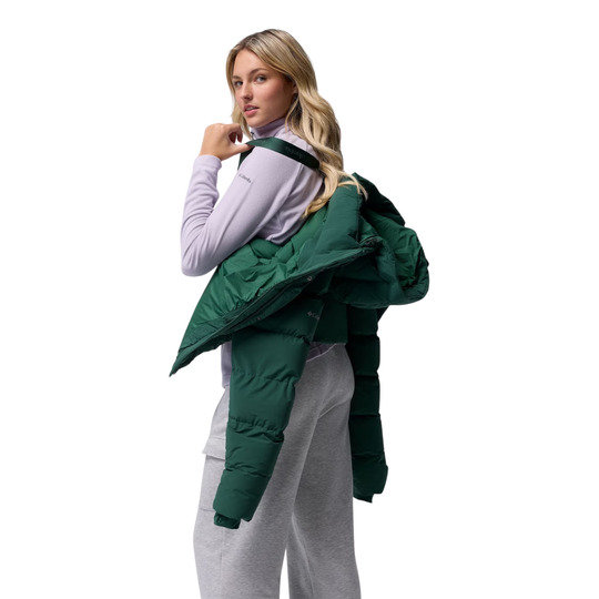 woman wearing Columbia Women's Amaze Puff Hooded Jacket - Rain Forest on plain white background. Showing off the suspender shoulder system to hook the jacket.