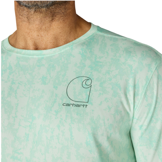 man wearing Carhartt Men's Force Sun Defender Relaxed Long Sleeve T Shirt - Fresh Mint Camo on a plain white background. Zoomed in to Carhartt logo on upper pectoral section. 