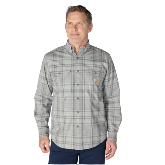 A man wearing a long-sleeve gray and white plaid button-down shirt with a small Carhartt logo on the chest pocket, paired with navy pants, against a plain white background.