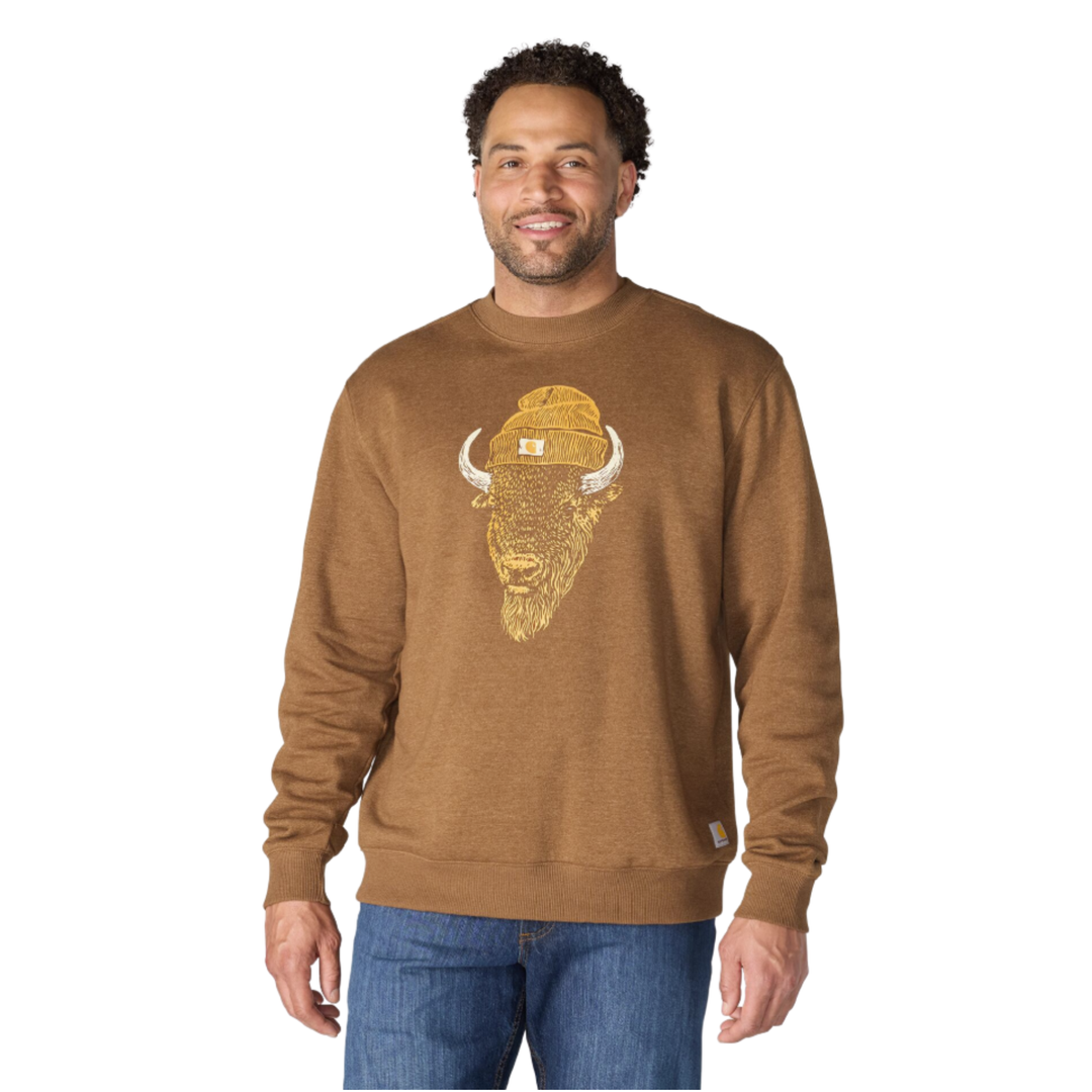 A man wearing a brown crewneck sweatshirt with a gold bison graphic on the front, paired with blue jeans, against a plain white background.