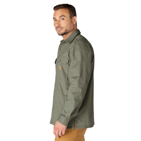 A man wearing an olive green long-sleeve button-up shirt with a chest pocket, shown in profile against a plain white background.
