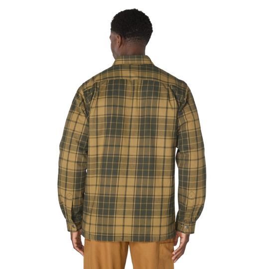 A man viewed from the back wearing a long-sleeve plaid overshirt in tan and dark green, paired with tan pants, against a plain white background.