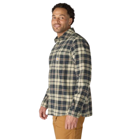 A man wearing a long-sleeve plaid button-up shirt in green, beige, and white, paired with tan pants, shown from a side profile against a white background.