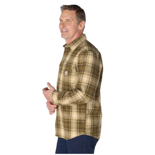 A man wearing a long-sleeve plaid flannel shirt in olive green and beige, paired with dark blue pants, shown from a side profile against a white background.