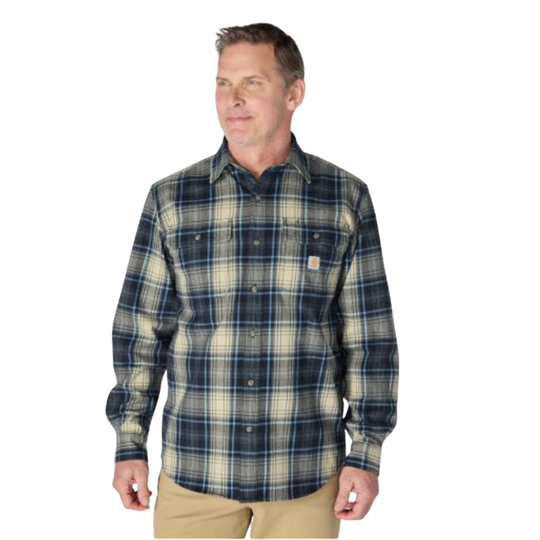 A man wearing a Carhartt long-sleeve plaid button-up shirt in navy, beige, and gray, paired with khaki pants, against a plain white background.