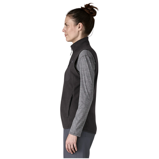 A woman shown in side profile wearing a dark gray ribbed zip-front vest over a heather gray long-sleeve shirt, against a plain white background.
