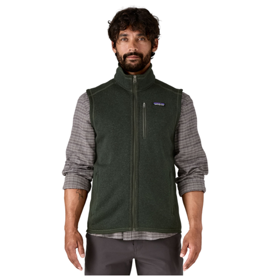 A man wearing a dark green Patagonia fleece vest over a gray and white plaid long-sleeve shirt, shown against a plain white background.