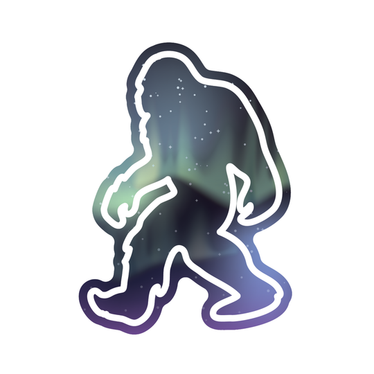 A die-cut sticker featuring a silhouette of Bigfoot filled with a dark galaxy and aurora pattern, outlined in white, on a solid white background.