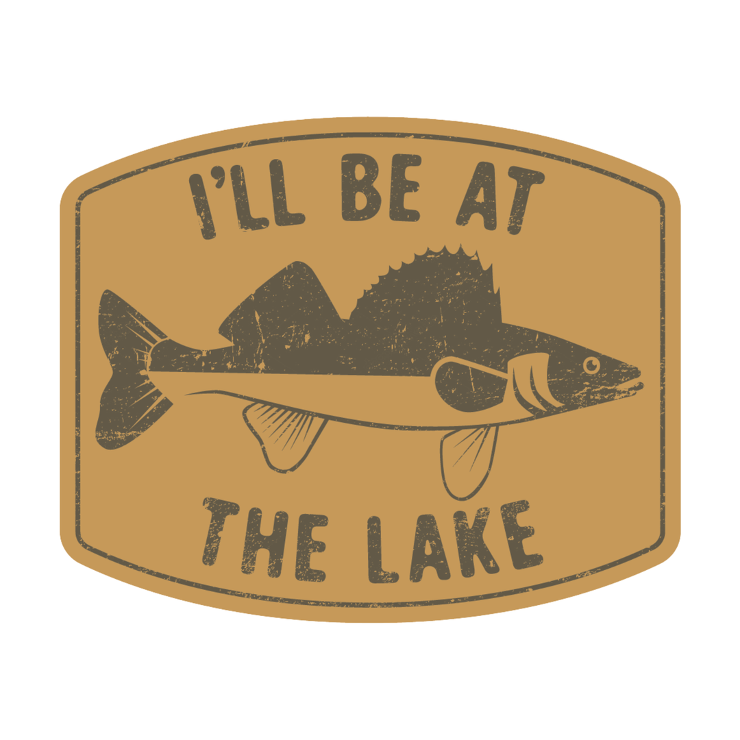 A rectangular sticker or patch with rounded corners featuring a distressed fish illustration and the text 'I'LL BE AT THE LAKE' on a tan background.