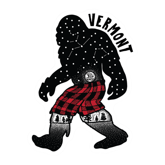 A stylized graphic of a Bigfoot figure walking, with the word 'VERMONT' above. The Bigfoot silhouette is black with white dots and constellation lines, wearing red-and-black plaid shorts and black-and-white spotted socks with a pine tree pattern.