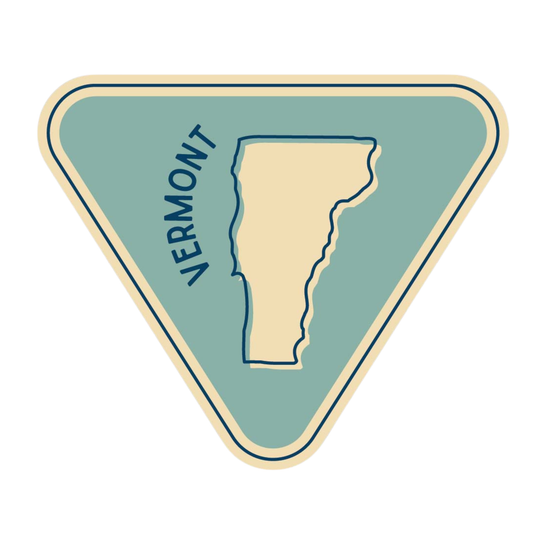 A triangular sticker or patch design with a light blue-green background, a cream-colored outline of Vermont in the center, the word 'VERMONT' written vertically in dark blue along the left side, and a cream border around the edge.